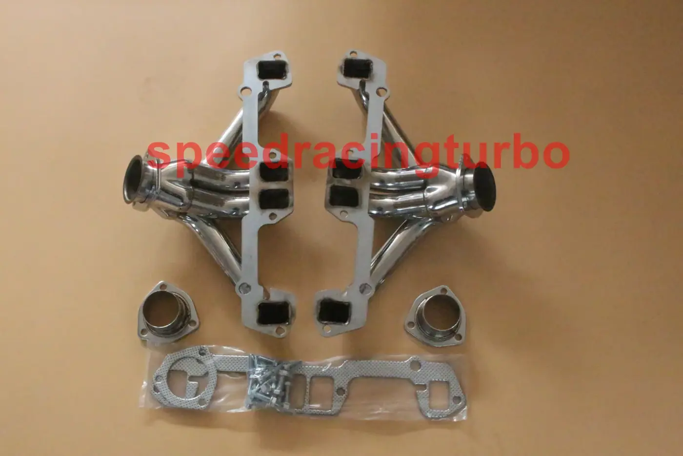 Side view of a shorty exhaust header kit with gaskets and bolts laid out