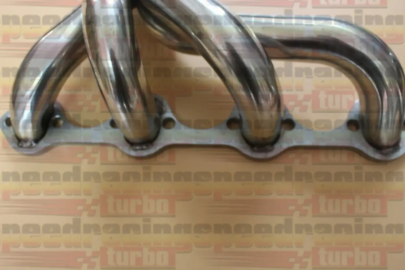 Top view of the header showing the polished finish and round port flange pattern