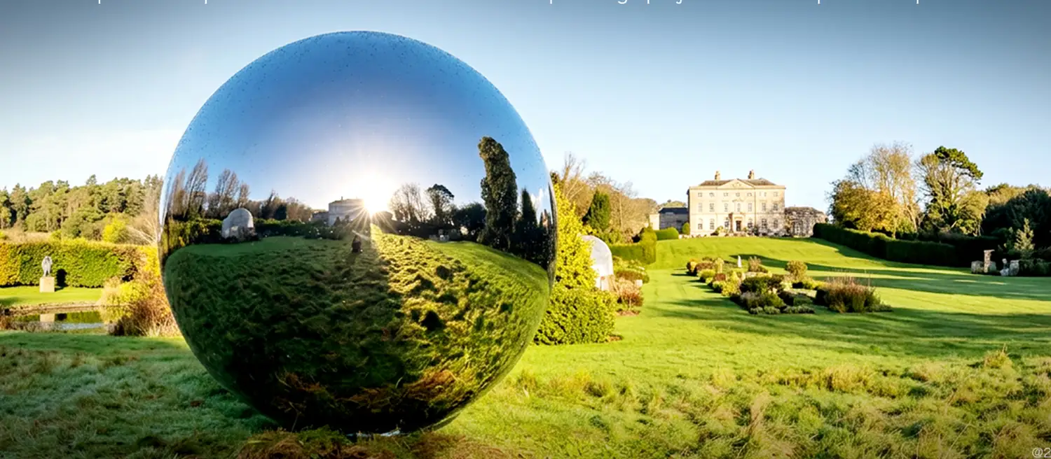 Large mirror polished stainless steel sphere in an estate garden