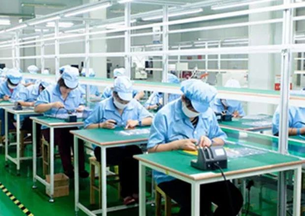 Technicians assembling battery packs at workbenches
