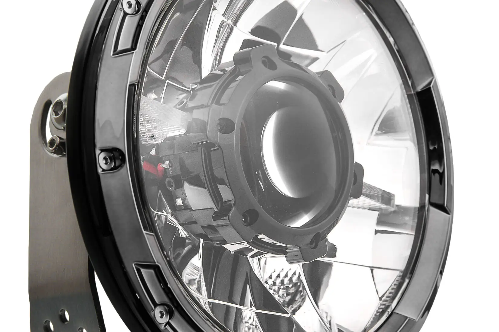 Close-up of a circular industrial light fixture with a polished metal reflector and mounting bracket.