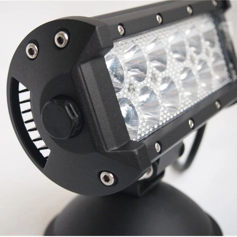 Close-up of a black LED work light bar with multiple reflectors and a mounting bracket