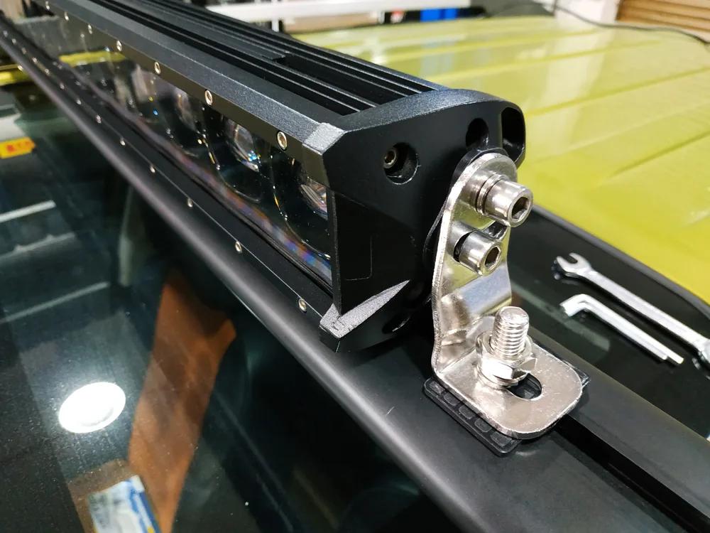 Black extruded aluminum light fixture mounted to a silver bracket with two side connectors.