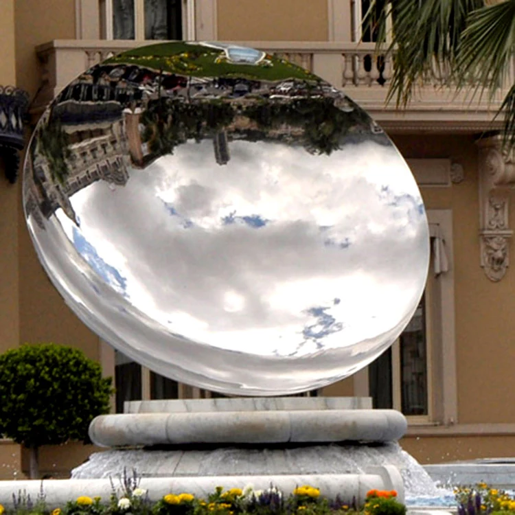 Concave mirror sculpture with mirror polish installed in a garden setting