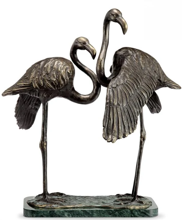Cast copper flamingo standing in a garden landscape with natural patina