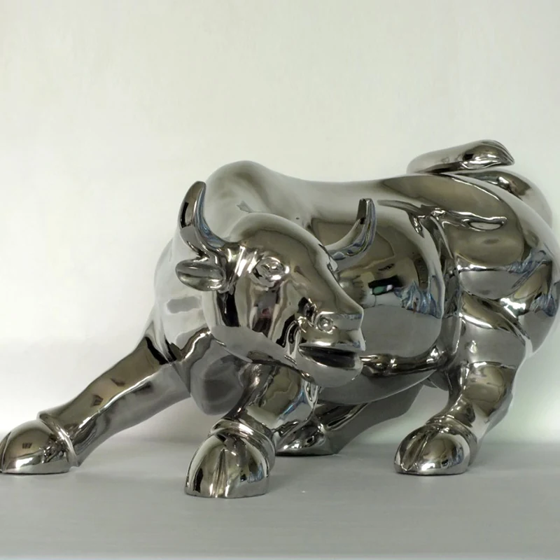 Mirror polished stainless steel cow sculpture standing in a public plaza