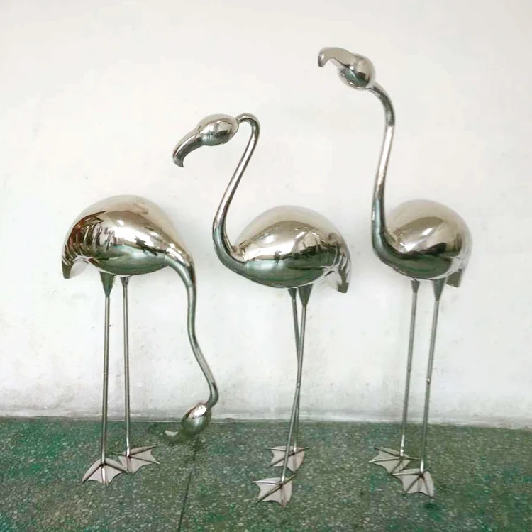 Hand forged stainless steel flamingo sculpture standing on a park plaza