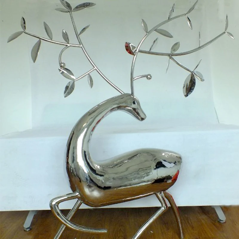 Stainless steel sika deer sculpture standing in a park landscape