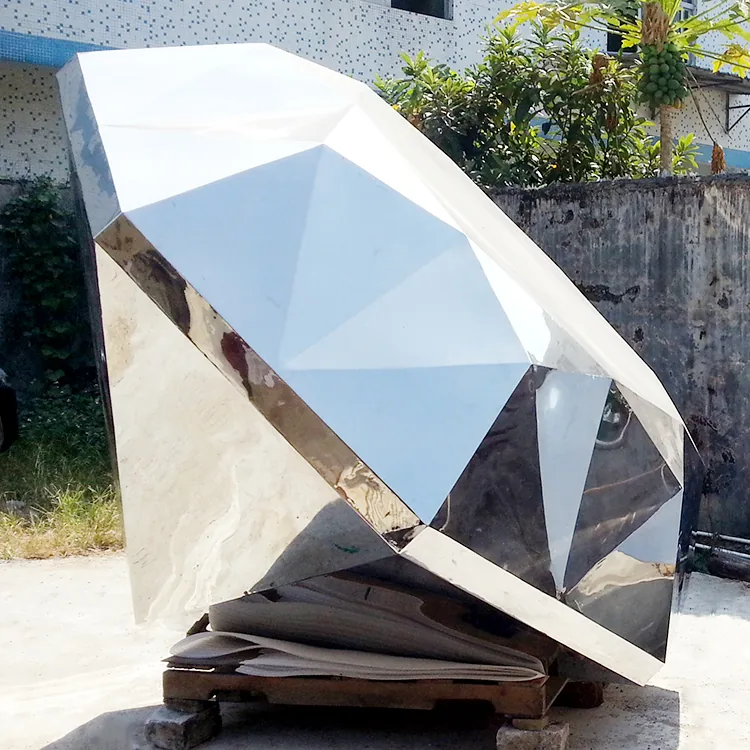 Mirror polished stainless steel diamond sculpture standing in a public plaza