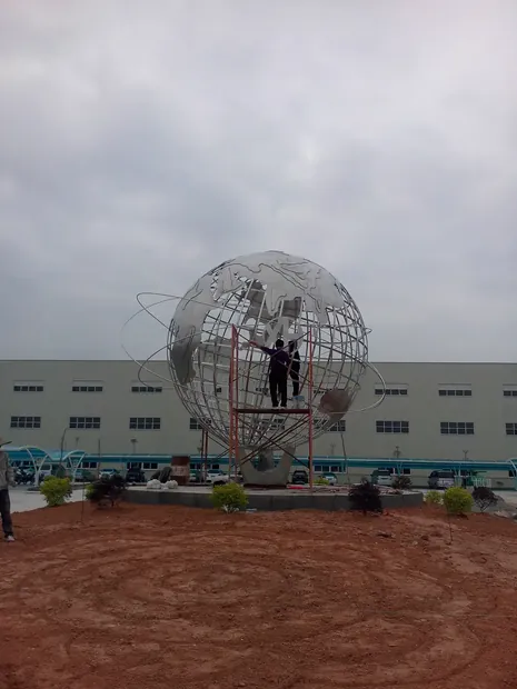 Globe with mirror polished tubes reflecting the sky and surrounding architecture