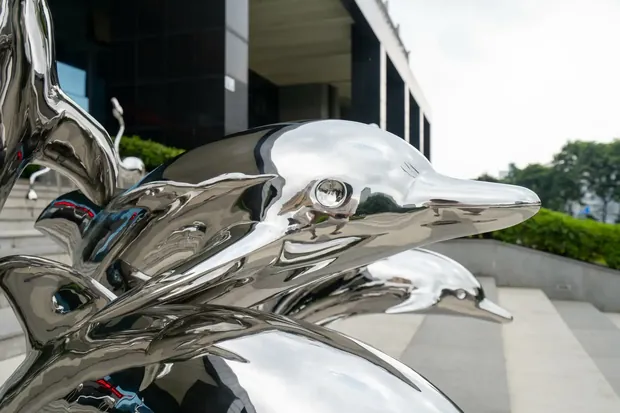 Side view of the flowing form of a hand forged stainless steel dolphin