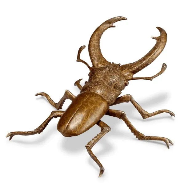 Copper cast beetle sculpture on a display platform, showing fine surface detail
