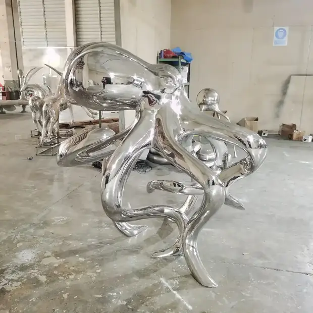 Stainless steel octopus sculpture installed in a hotel lobby with natural light reflecting off the surface