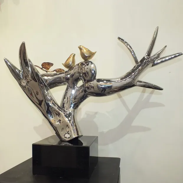 Stainless steel branch bird sculpture in a modern exhibition hall