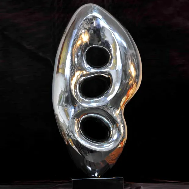 Mirror polished stainless steel bird sculpture reflecting ceiling lights