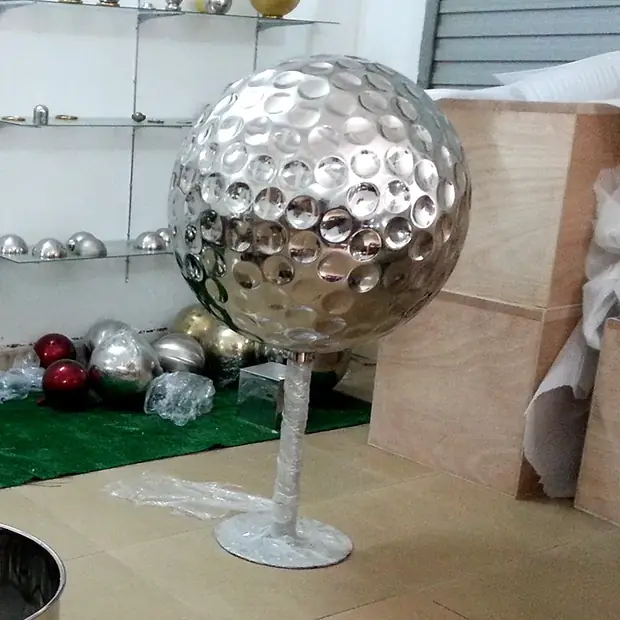 Close up of a polished stainless steel sphere reflecting a modern interior space
