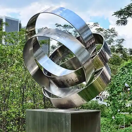 Continuous ribbon sculpture in brushed satin finish, viewed from the side