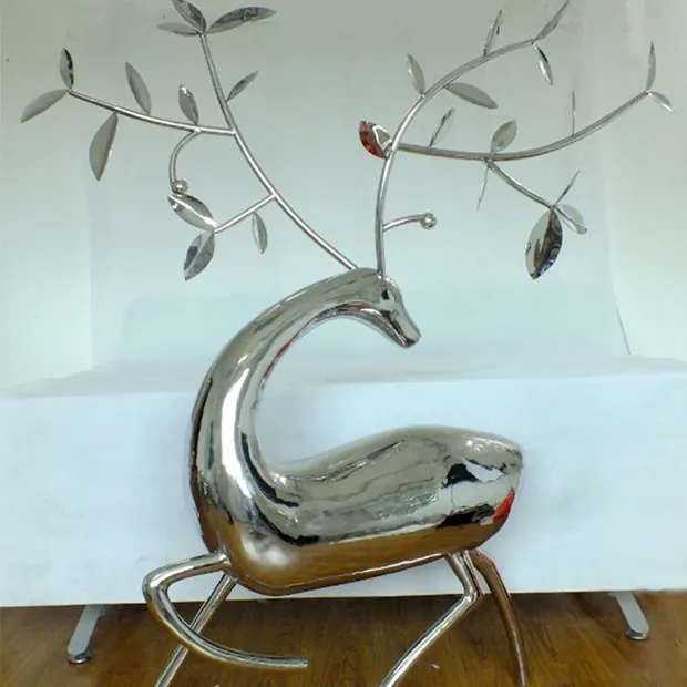 Stainless steel sika deer sculpture standing in a park landscape