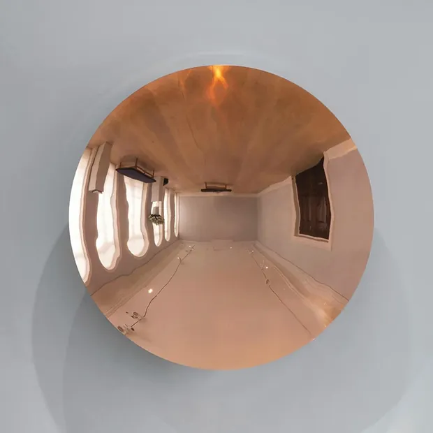 Stainless steel ball top reflecting light and surrounding architecture