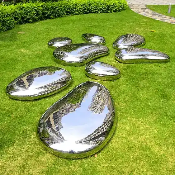 Stainless steel pebble cluster placed on paving in a public plaza