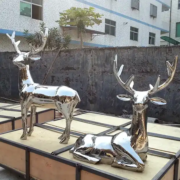 Stainless steel Sika deer sculpture standing on a park lawn with natural polished finish
