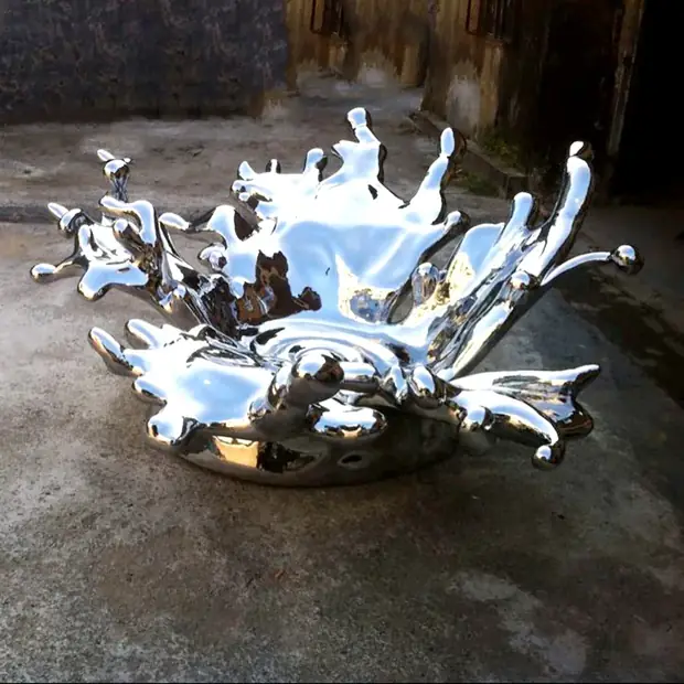 Abstract stainless steel spray sculpture with mirror polished surface in a modern interior