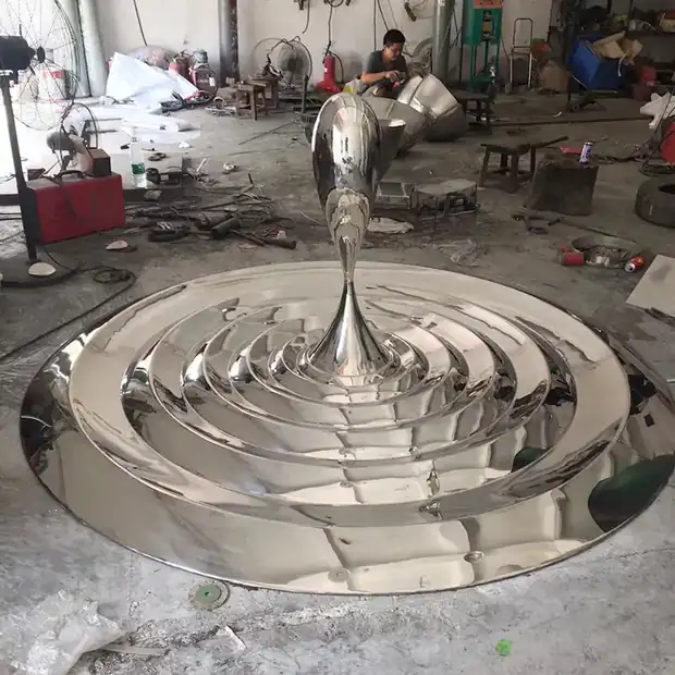 Close-up of mirror polished stainless steel water droplets and floral forms