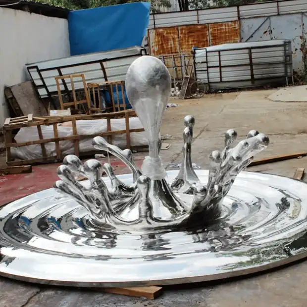 Stainless steel sculpture of water droplets and flowers in a flowing arrangement