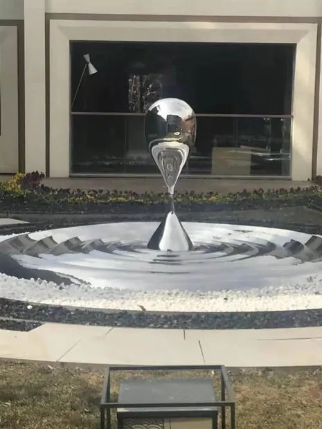 Close-up of water drop forms on a stainless steel sculpture surface
