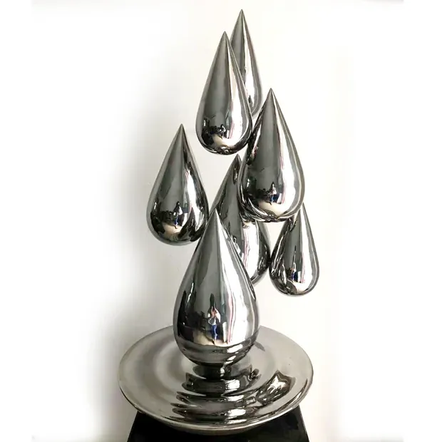 Stainless steel water drop sculpture in a public garden setting