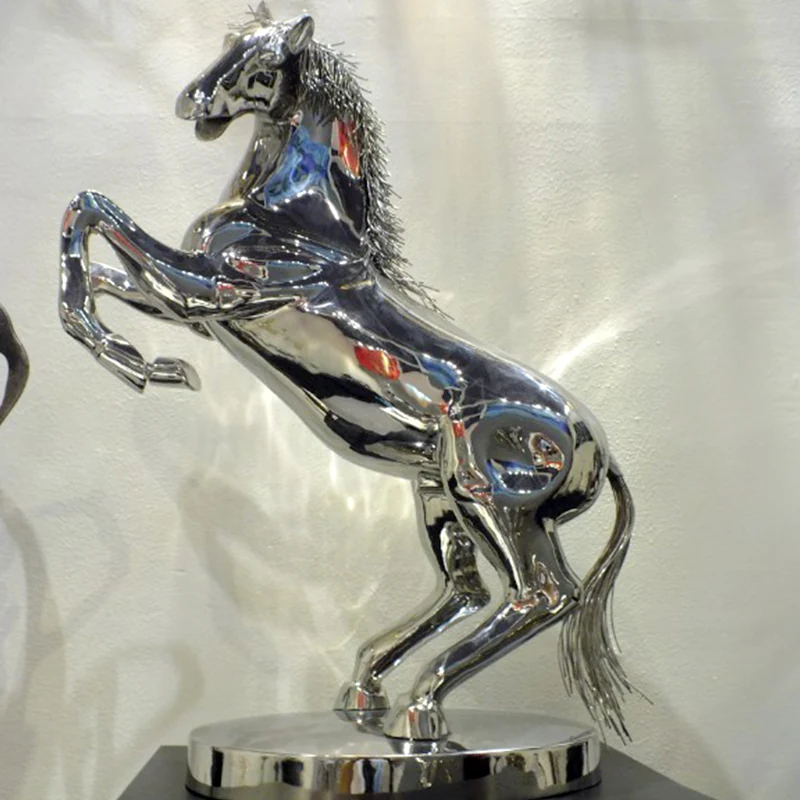 Mirror polished stainless steel horse sculpture on a wooden desk