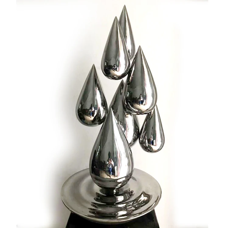 Stainless steel droplet sculpture with mirror finish on a white background
