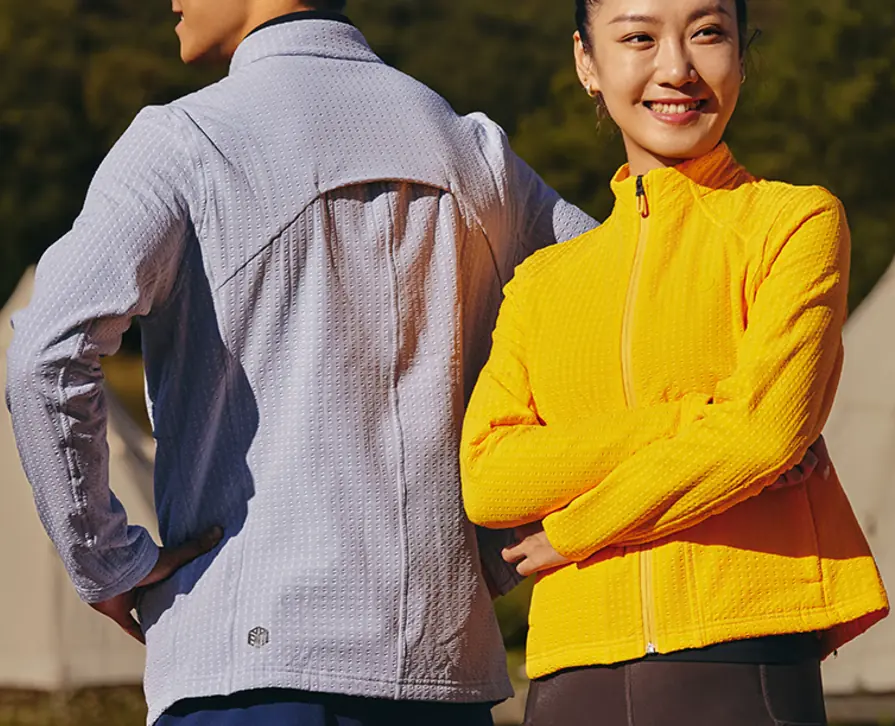 Two runners wearing Tanbei Garments running jackets photographed outdoors