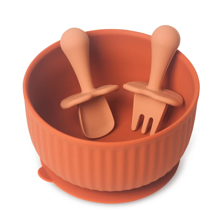 Set displayed on a high chair tray with a baby's hand reaching for the spoon