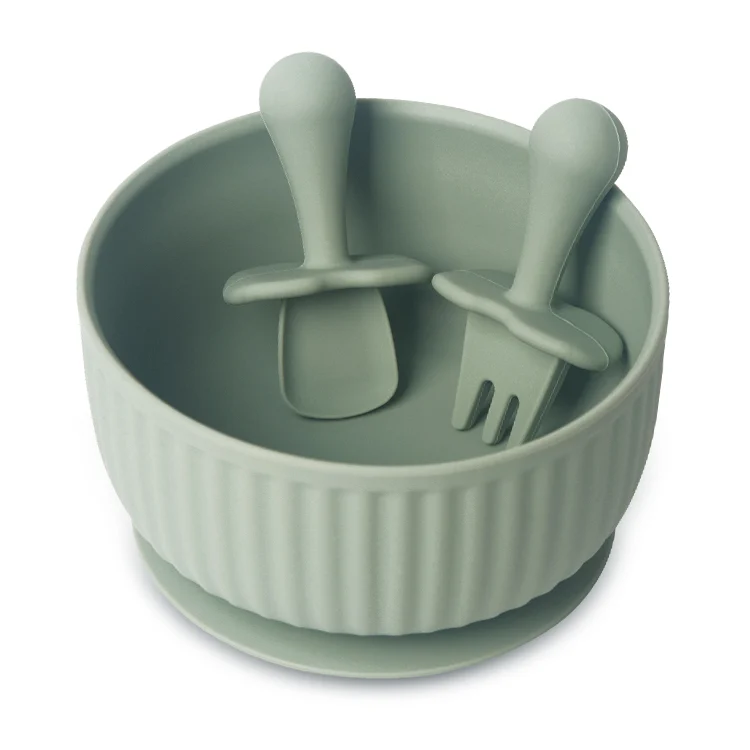 White silicone suction bowl set with spoon and fork on a white surface