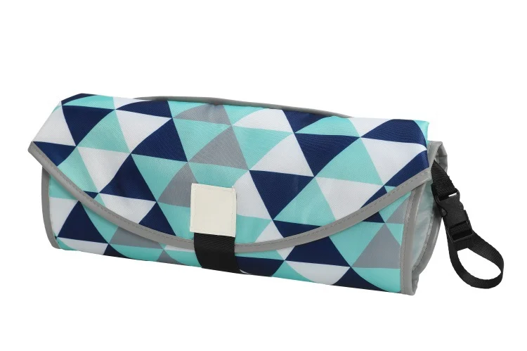 Side view of the pad showing the foldable barrier and hanging toy attachment point