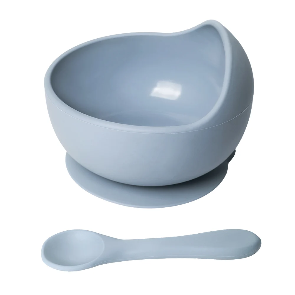 Pink suction silicone bowl with integrated spoon on a high chair