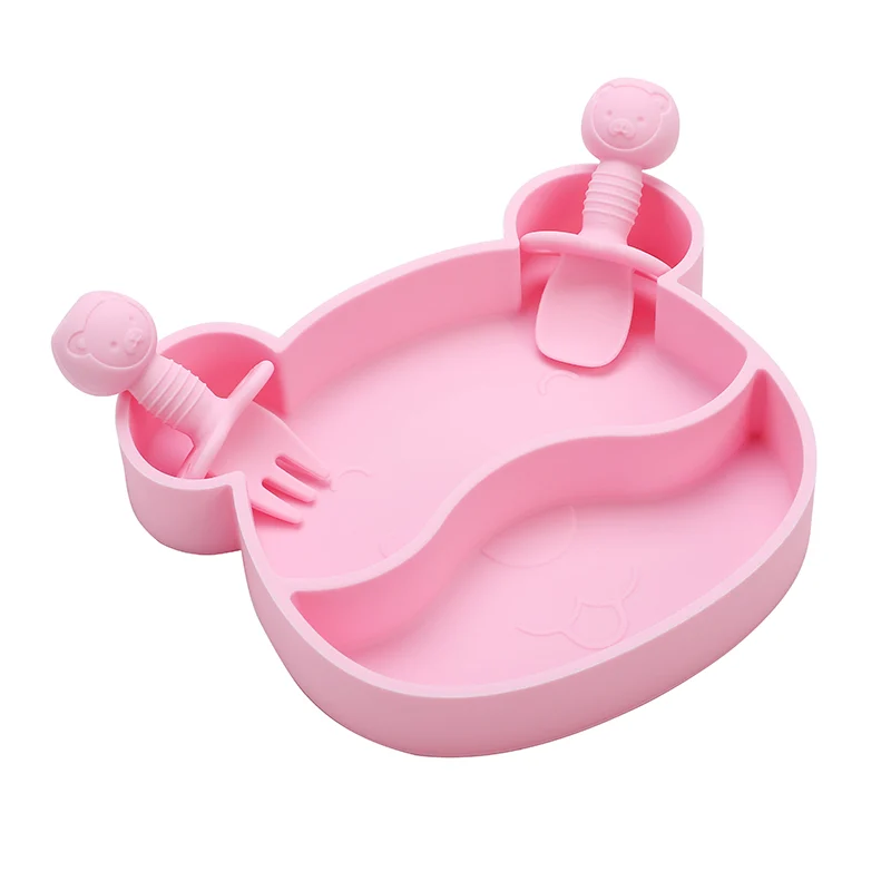 Bowl with two sections filled with food, spoon and fork placed beside it