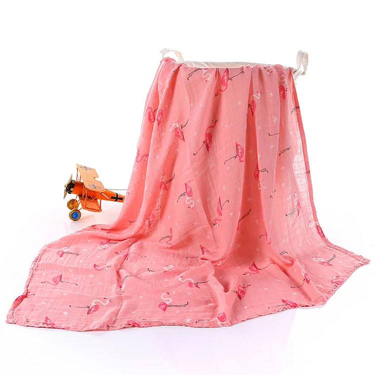 Green bamboo cotton swaddle blanket used as a nursing cover