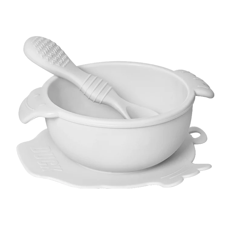 Blue duck-shaped baby bowl and spoon set with the suction base pressed down