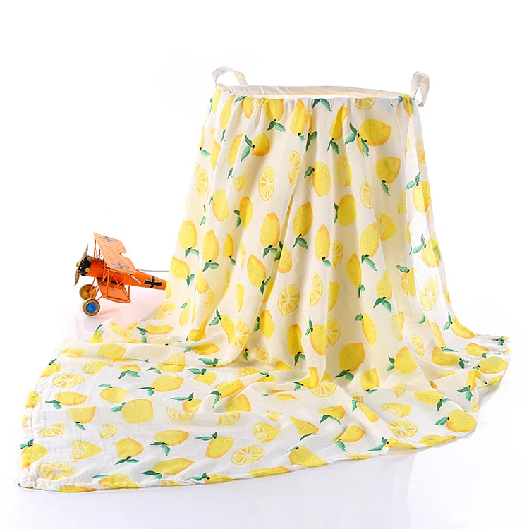 Yellow bamboo cotton swaddle blanket placed on a changing table