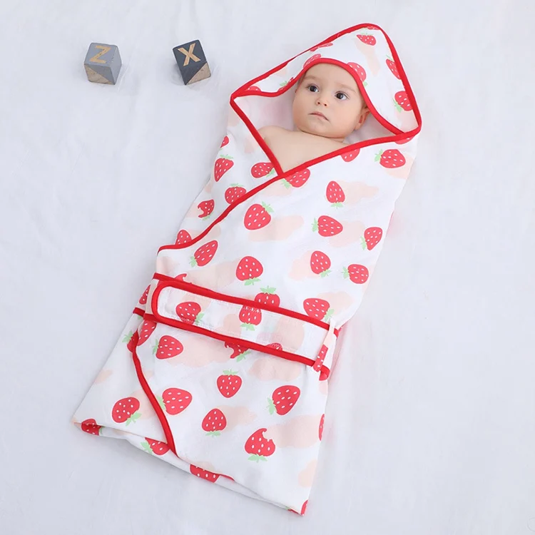 Grey cotton swaddle blanket folded in a compact bundle, ready for travel