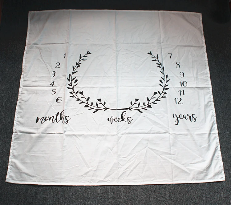 Multiple baby milestone blankets in different colours laid out side by side