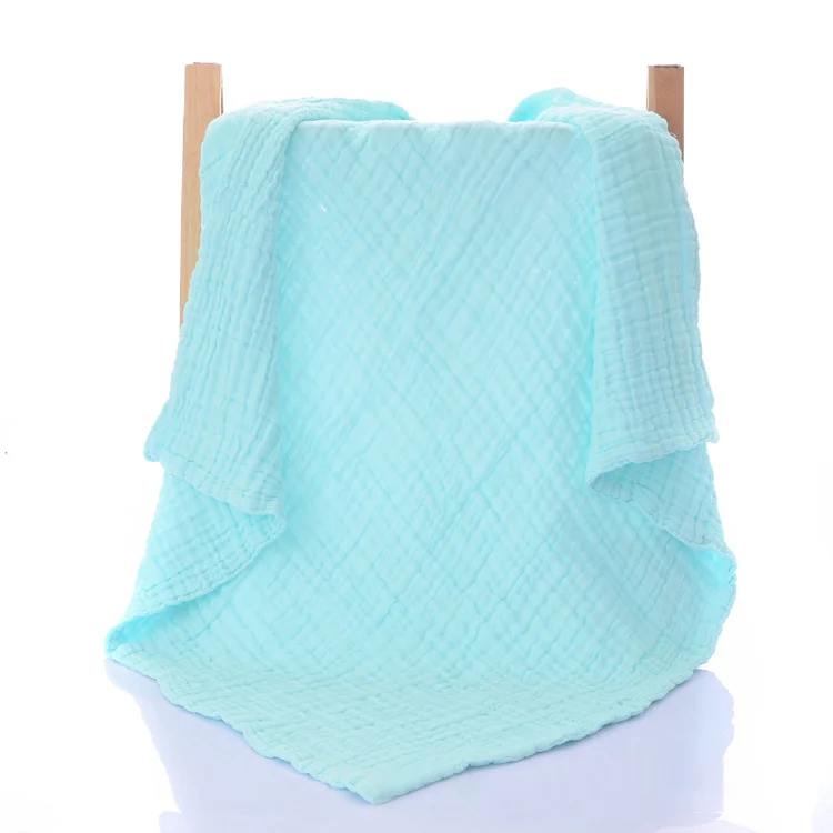 White 6-layer knitted baby blanket used as a nursing cover