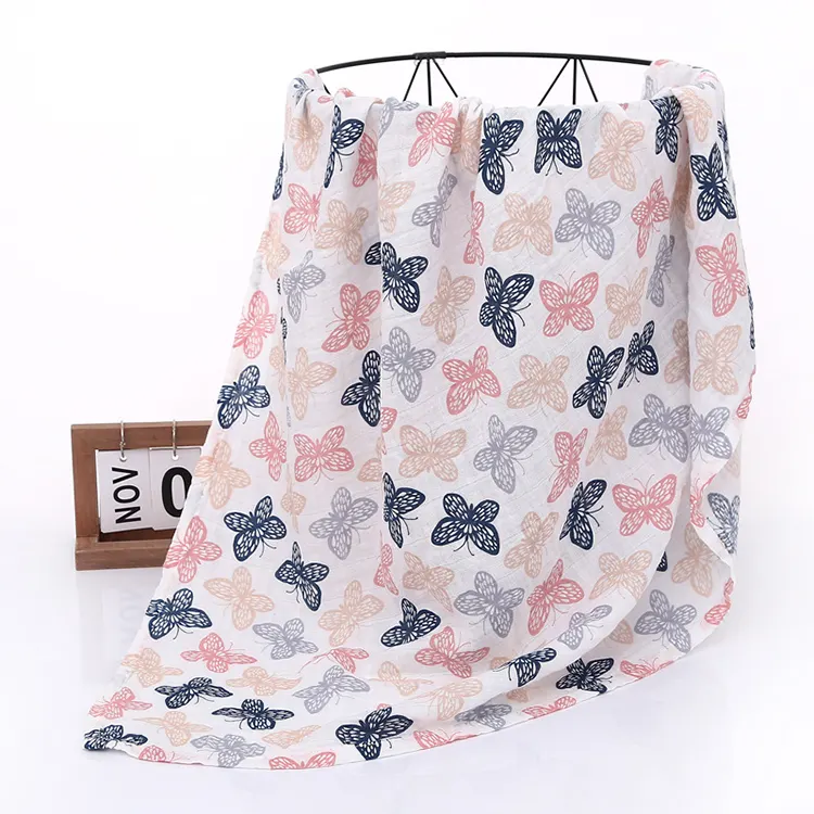 Orange floral muslin swaddle blanket in a folded stack