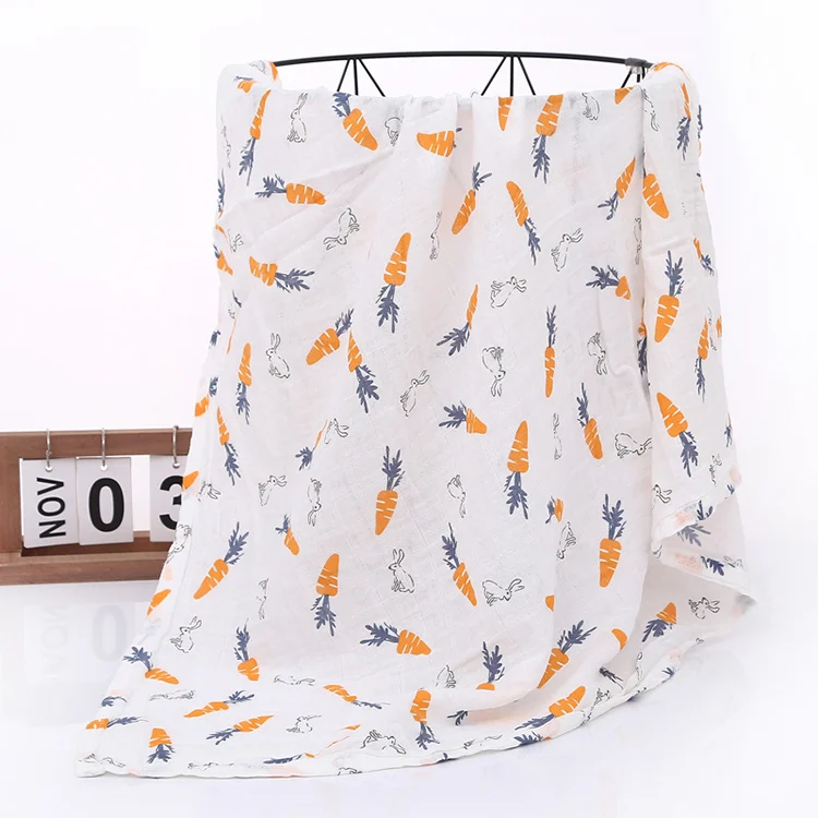 White floral muslin swaddle blanket with detailed pattern close-up