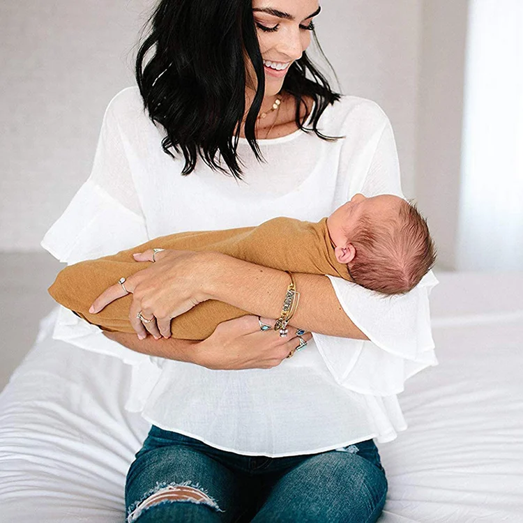 Swaddle blanket folded into a compact size with headbands stored inside