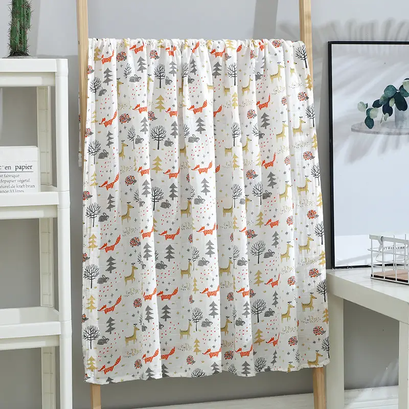 Blue animal-patterned muslin swaddle blanket wrapped around a baby dummy