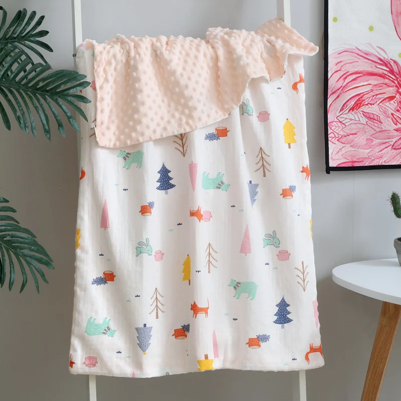 Orange baby blanket with floral and animal print, laid out on a changing table