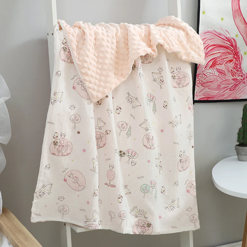 Green baby blanket with cartoon animal print, displayed open to show both sides